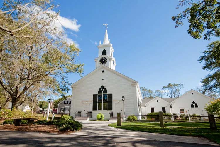 The front of the Dennis Union Church with clock and spire visible